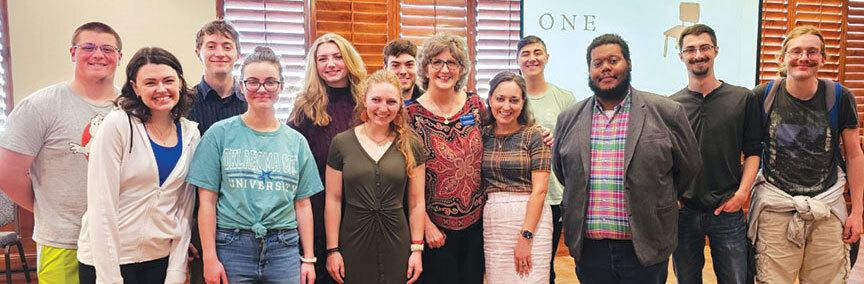 Thirteen people smiling at camera