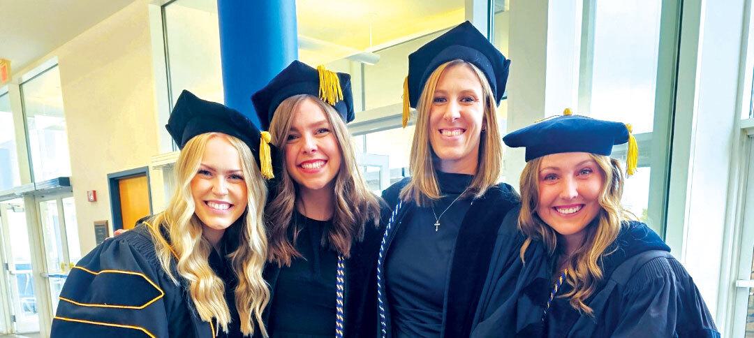 Four women in caps and gowns